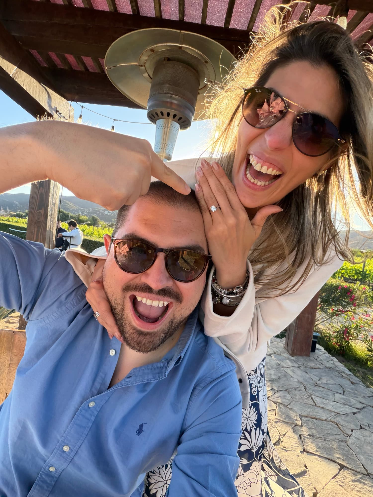 Betty mostrando el anillo junto a Mike bajo la pérgola